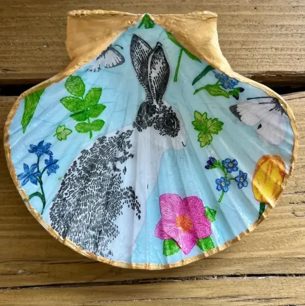 a picture of a rabbit decoupaged onto a scallop shell